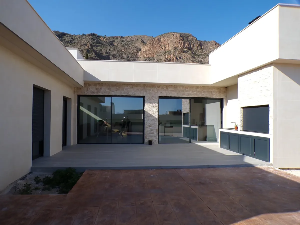 Grandes puertas correderas de aluminio negro y cristal en el patio de una vivienda