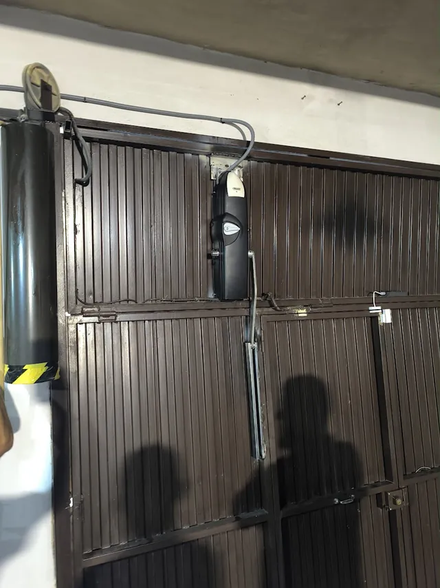 Motor instalado en una puerta basculante metálica de garaje