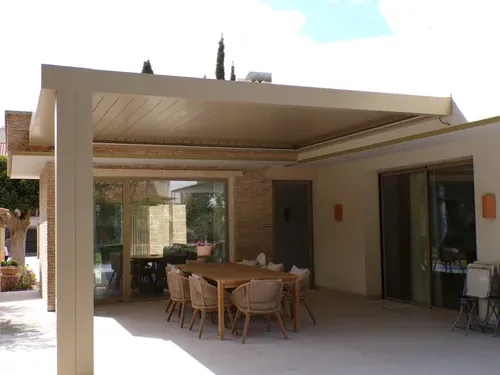 Pérgola de lamas color marfil sobre la terraza de una vivienda