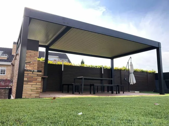 Pérgola de lamas negra sobre una zona de comedor en el jardín