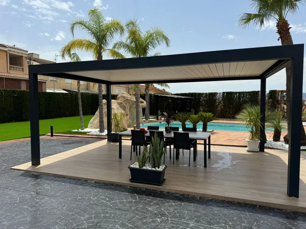 Pérgola de lamas orientables en gris antracita junto a una piscina