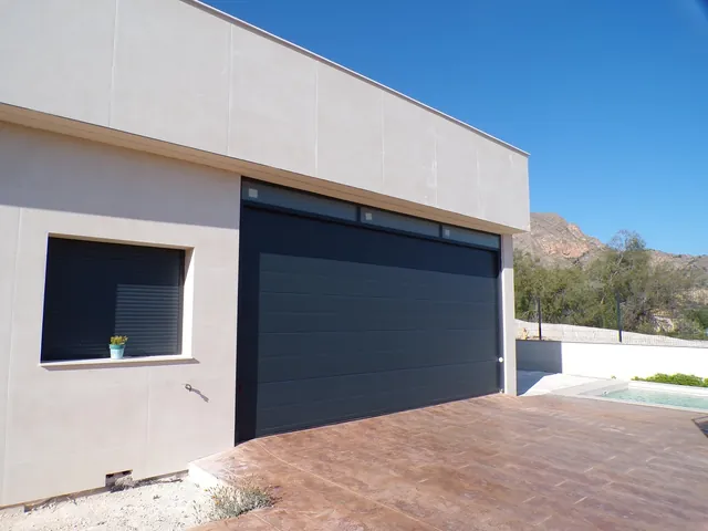 Puerta seccional de garaje en gris antracita con franja acristalada